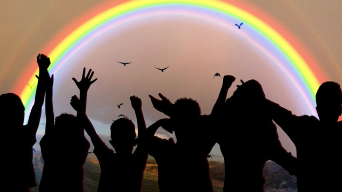 Kinder feiern unter Regenbogen