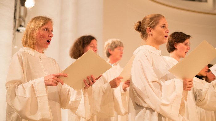 Ein Frauenchor singt in weißen Kleidern