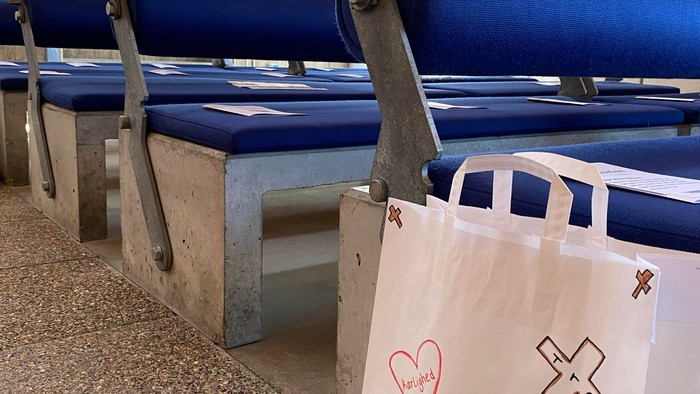 Blå bænke med blomster og hvid plasttøj på kirkegård