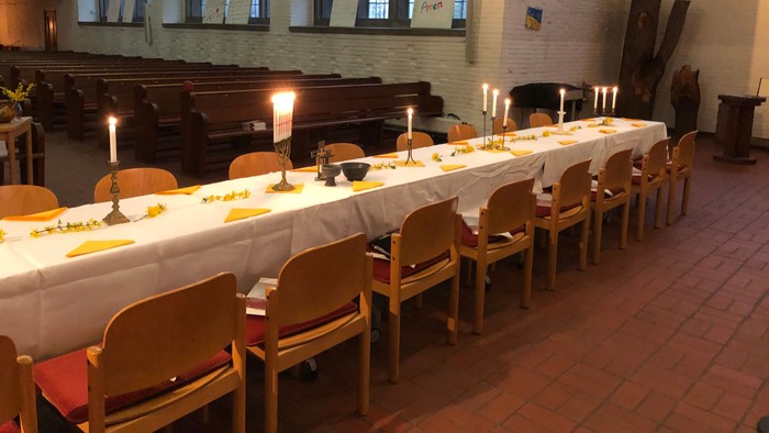 Festlich gedeckter Tisch in der Kirche, für das Agapemahl am Gründonnerstag