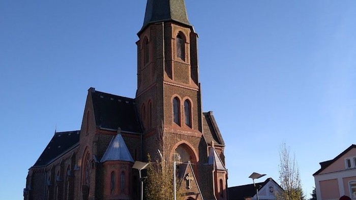 Große Kirche mit hohem Turm an der Straße.