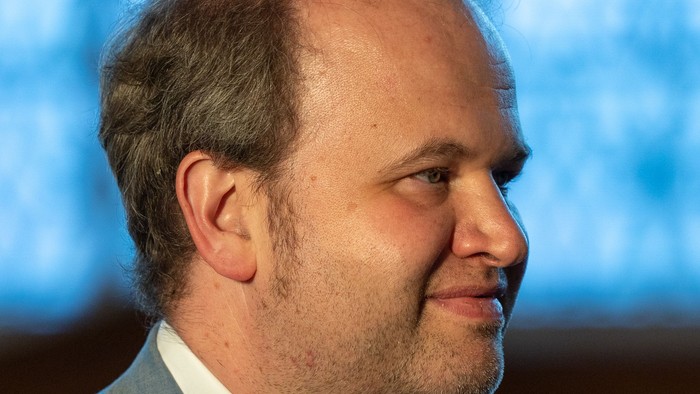 Mann im Anzug mit Krawatte, leicht lächelnd