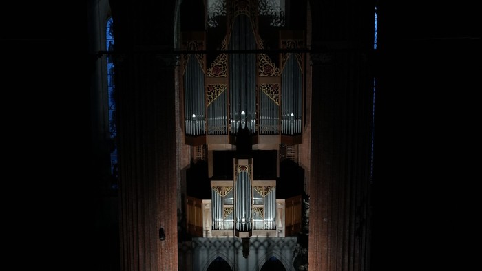 Große Pfeifenorgel, beleuchtet in einer dunklen, prunkvollen Kathedrale.
