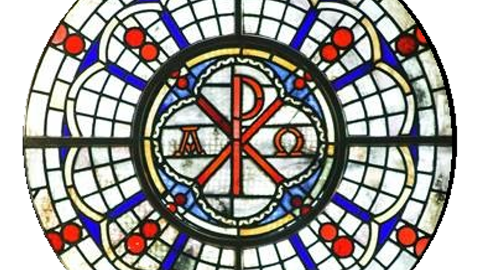 Das Bild zeigt ein buntes, kreisförmiges Kirchenfenster mit christlichen Symbolen.