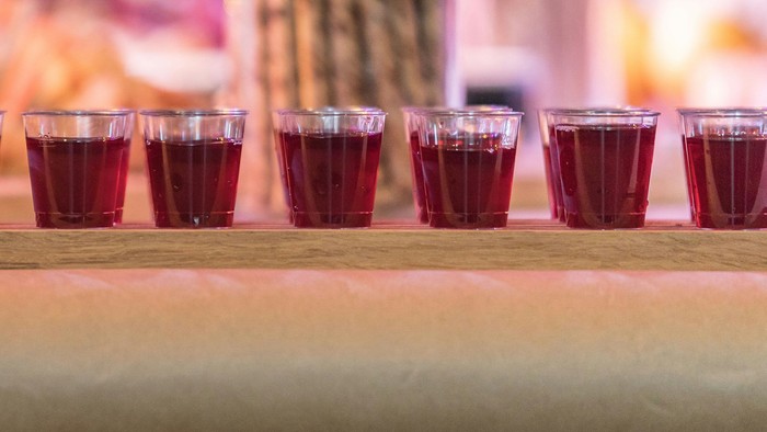 Eine Reihe roter Shotgläser auf einem Tisch bei einer Party