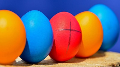 Bunte Ostereier in einer Reihe auf einem Holzstück