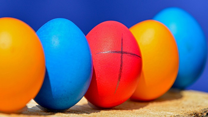 Bunte Ostereier in einer Reihe auf einem Holzstück