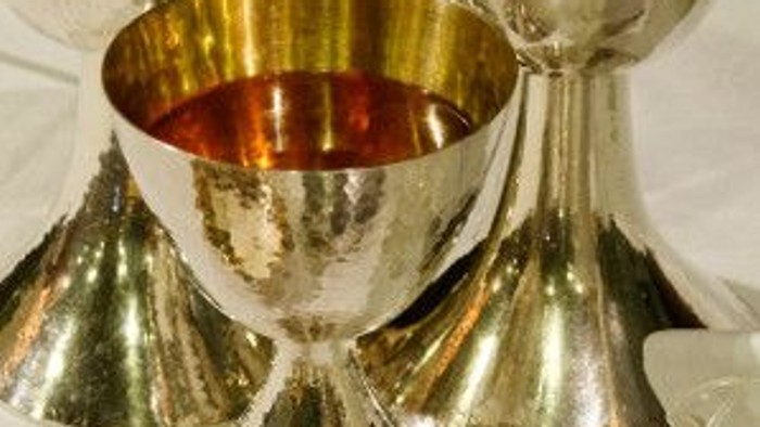 Verschiedene silberne und goldene Pokalen und Schalen auf weißem Tisch