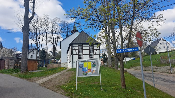 Weißes Fachwerkhaus mit Schildern an der Straße