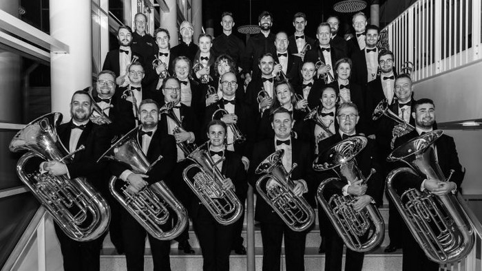 En gruppe musikanere poser med deres instrumenter på en trappe