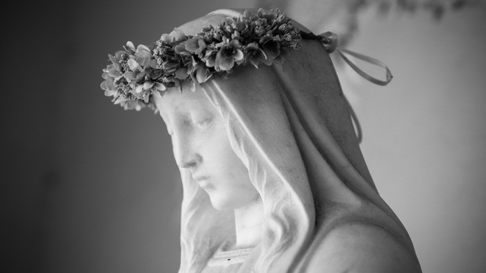En sort-hvid statue af en kvinde med en blomsterkrone.