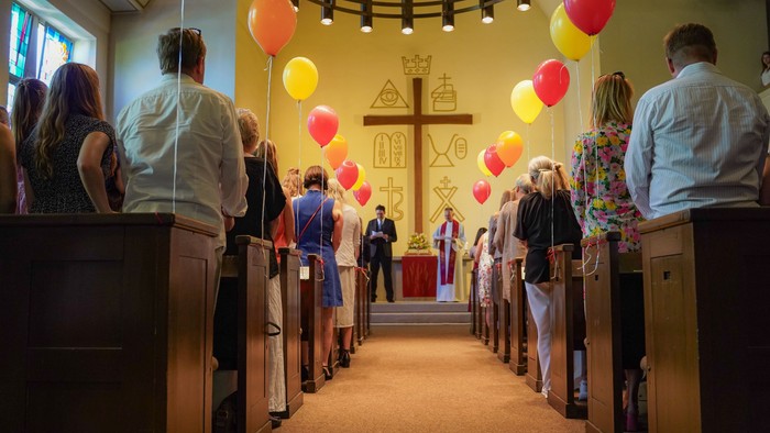 Konfirmation in der Friedenskirche: Der mit Luftballons geschmückter Mittelgang führt zum Altar, wo Pfarrer Burkhard Weitz und Theaterpädagoge Simon Isser die Gemeinde begrüßen