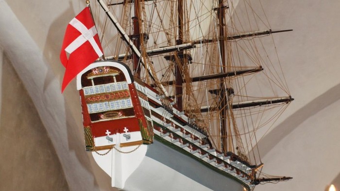 En modelleskib af en skonnert med dansk flag på væggen