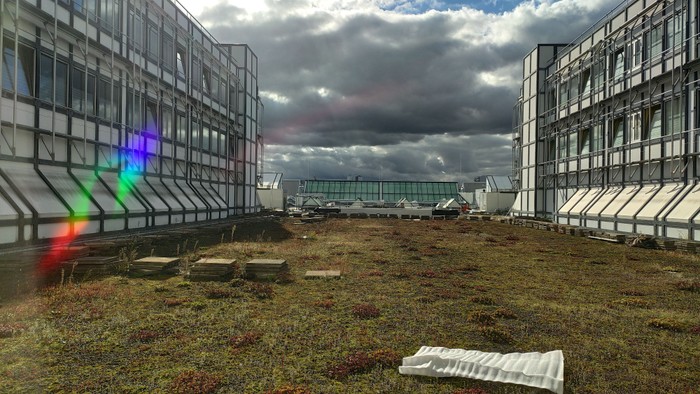 Ein großes Gebäude mit Glasfenstern und ein bewölkter Himmel.