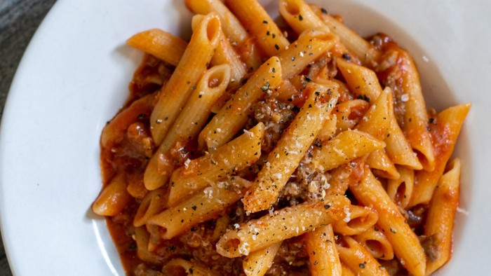 En bolle med penne med tomat sauce og ost