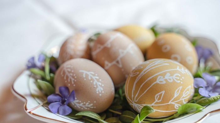 Bunte Ostereier auf einem Teller mit Blumen