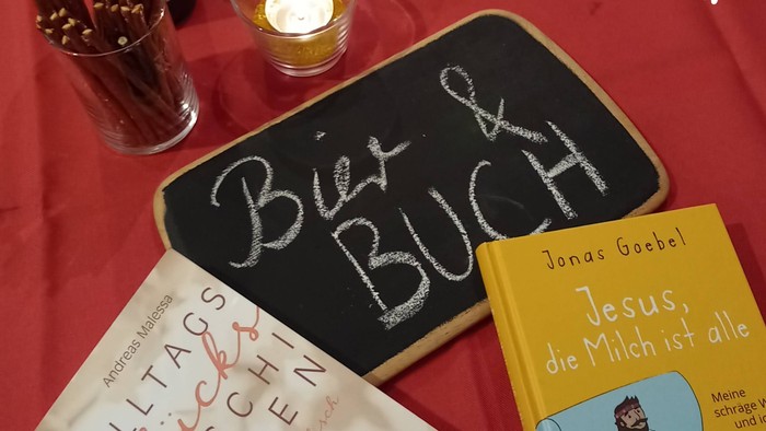 Herzliche IEnladung-zusehen ist eine Bierflasche und ein Buch 