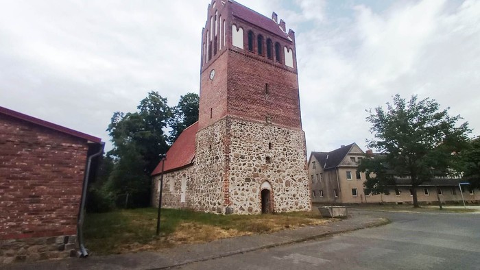 Alte Kirche mit Turm und Ziegelmauer in kleiner Stadt