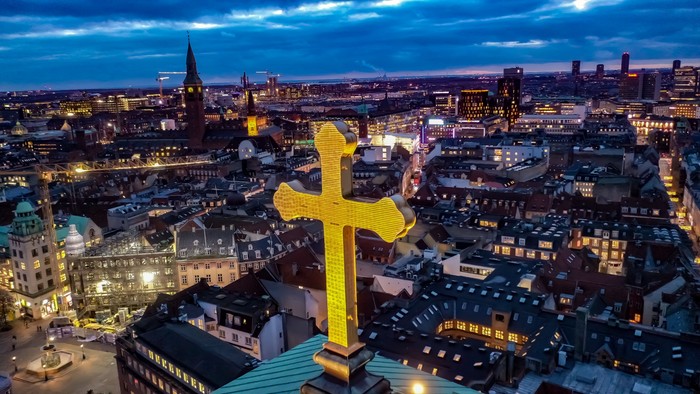 Byen ved aften med stor gul kors på et af tårnet