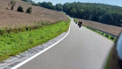 Motorräder fahren eine Landstraße entlang.