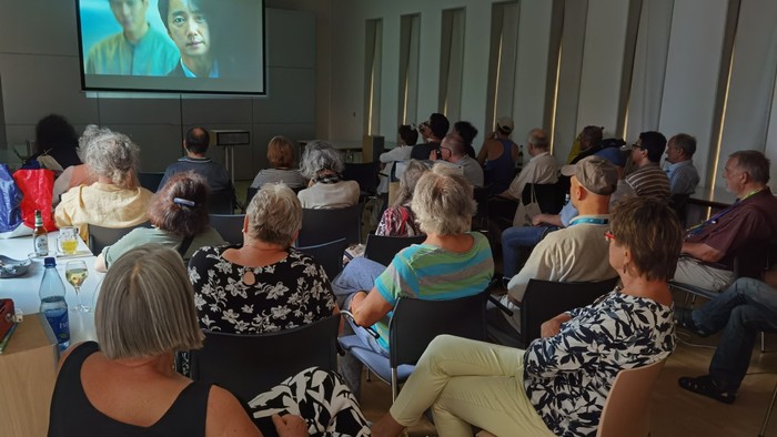 Eine Gruppe von Menschen schaut einen Film in einem Kino.