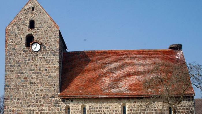 Alte Kirche mit Turm und Zifferblatt unter blauem Himmel