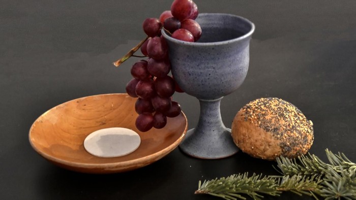 Wein, Brot und Trauben auf einem Holzteller