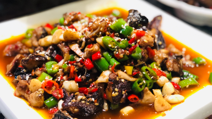Das Bild zeigt ein Gericht mit Fleisch und Gemüse in einer scharfen Sauce.