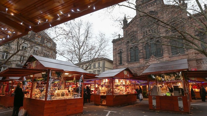 Marché de Noël avec des stands lumineux devant un bâtiment historique