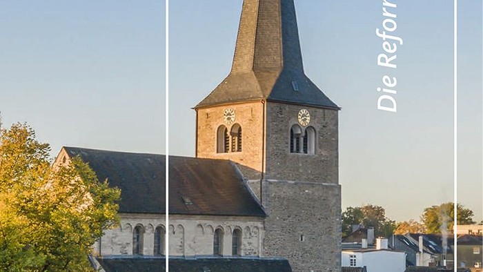 Eine historische Kirche mit hohem Kirchturm, die „Die Reformationskirche damals und heute“ der Evangelischen Kirchengemeinde Hilden präsentiert.