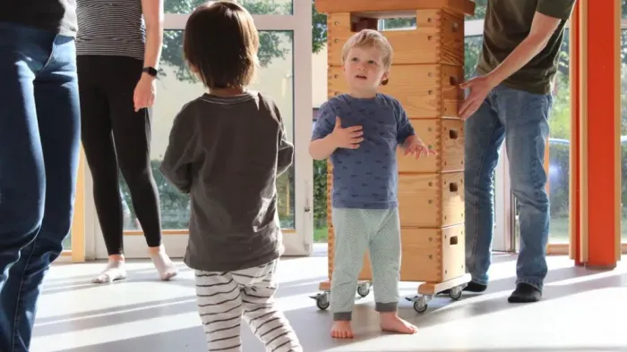 Kinder spielen drinnen, während Erwachsene in der Nähe sind.