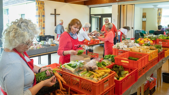 Freiwillige sortieren und organisieren frische Lebensmittel bei einer Lebensmittelverteilungsaktion in der Gemeinde.