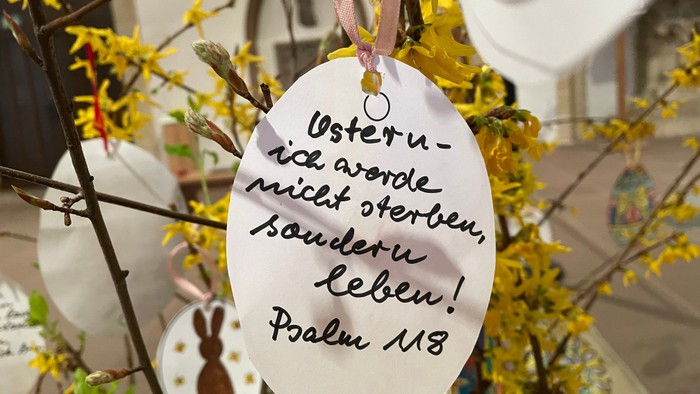 Osterei hängen an Zweigen, mit einem Zitat aus Psalm 118.