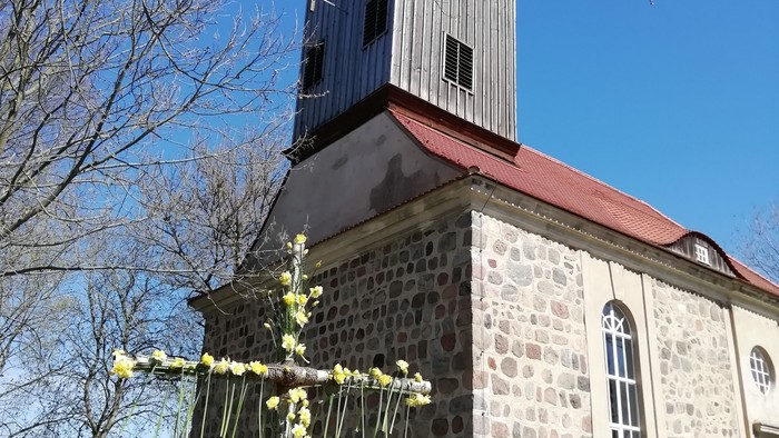 Kirchengrundstück mit blühendem Baum und klarem Himmel
