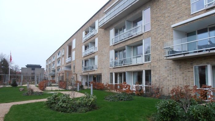 En moderne lejebolig med grønne arealer og balonger.