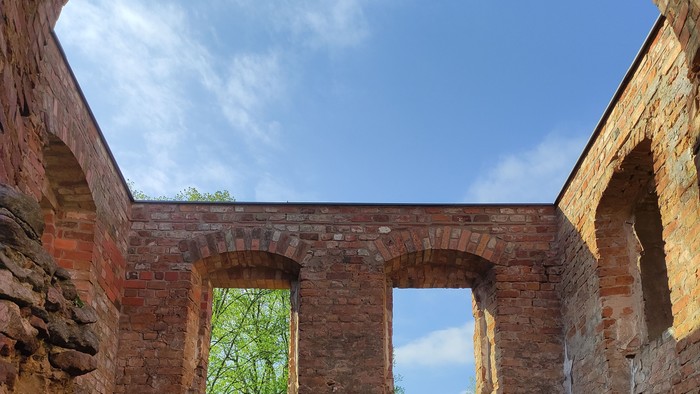 Blick aus der Kirchenruine in das Himmelsblau und das Frühlingsgrün vor dem Eingang.