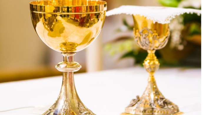 Elegante goldene Kelche, gefüllt mit Flüssigkeit, vermutlich für religiöse oder zeremonielle Zwecke verwendet.