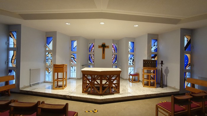 Die Kirche mit Altar, Stühlen und farbenfrohen Fenstern