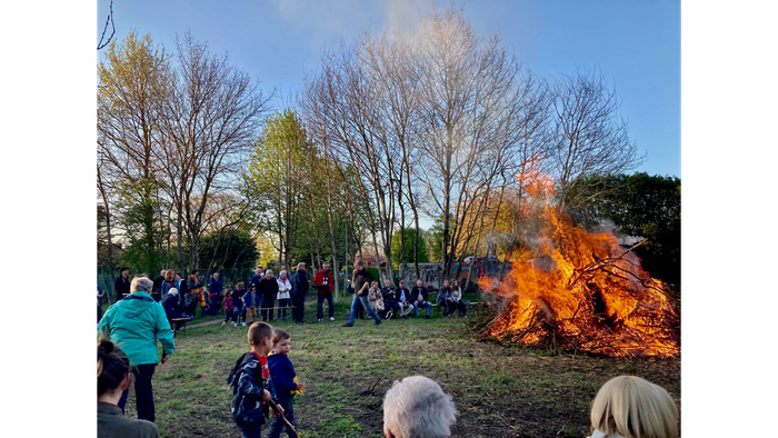 Menschen versammeln sich um ein großes Feuer im Freien