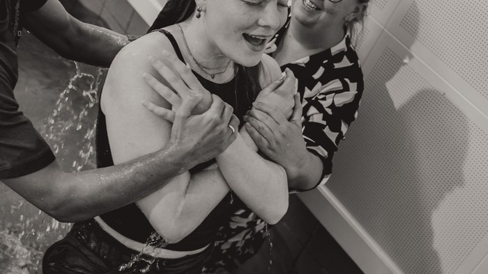 En ung kvinde danser med to mænd.