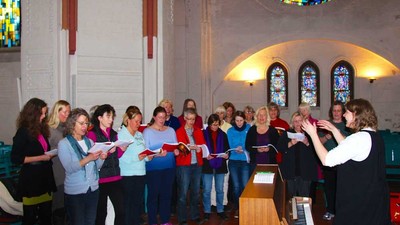 Eine Gruppe von Frauen singt in einer Kirche.