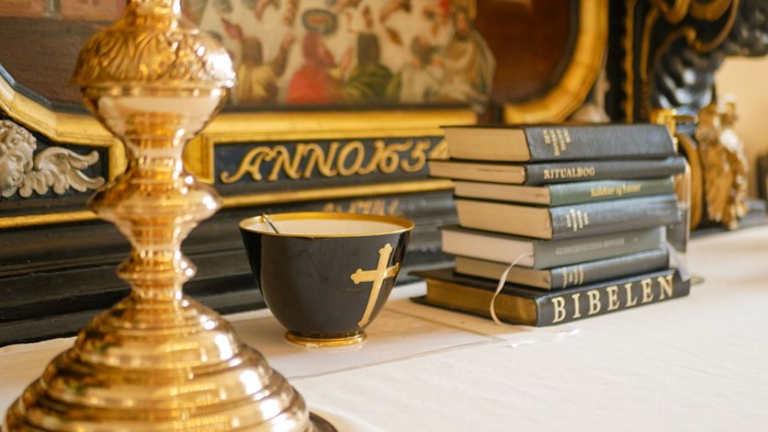 Guldfarvet lysestage og bøger på hylleshelf