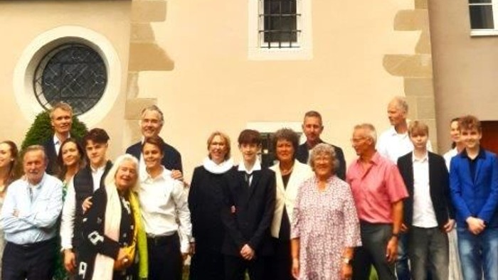 En gruppe af mennesker står foran et stort klokketårn.