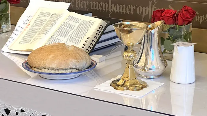 Alter med røde roser, bibel, vin og brød