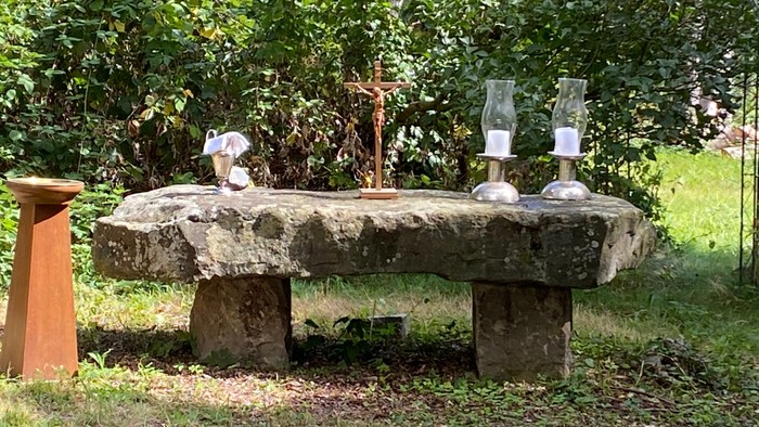 Steinerner Tisch im Garten mit Kerzen und Dekoration