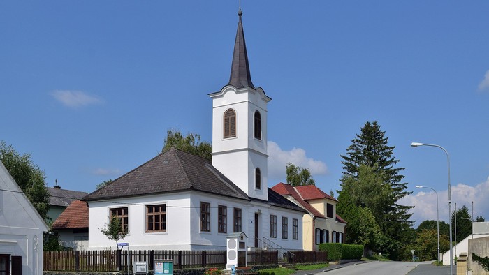 Weiße Kirche mit hohem Turm in kleinem Dorf