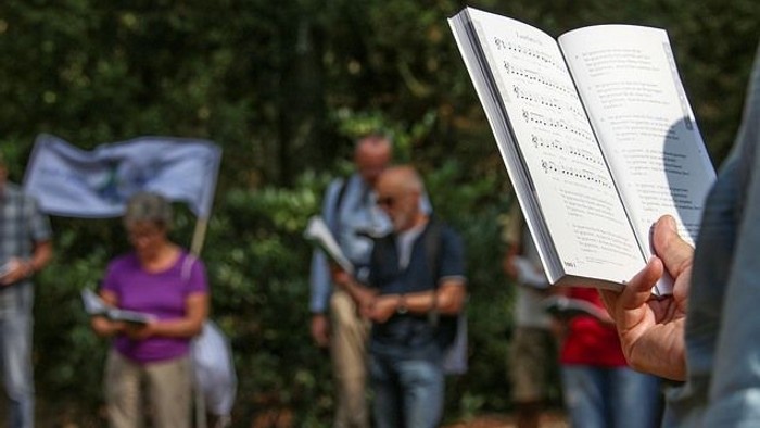 Menschen lesen Bücher im Freien, eine Frau hält eine Flagge