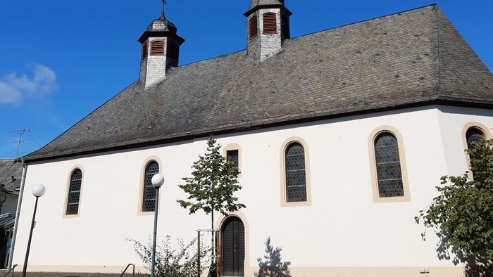 Weiße Kirche mit zwei Türmen und blauen Himmel