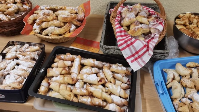 Verschiedene Gebäckstücke und Backwaren in Körben und Tabletts, bereit zum Servieren.