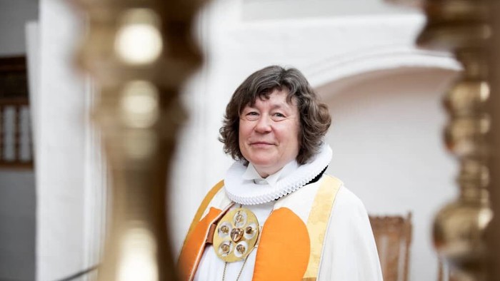 En kvinde i religiøst tøj står i en kirke.